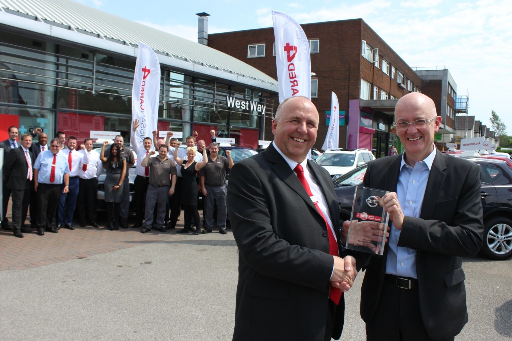 1.From left: David O’Grady, Dealer Principal at West Way Nissan Birmingham, is presented with the Nissan Global Award by James Wright, Managing Director of Nissan Motor (GB), with dealership staff celebrating behind