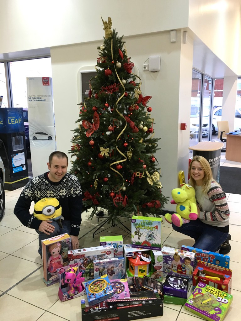 Sales Executive Chris Harrison and Service Advisor Danielle Evans with some of the presents dropped off at RRG Nissan Bury