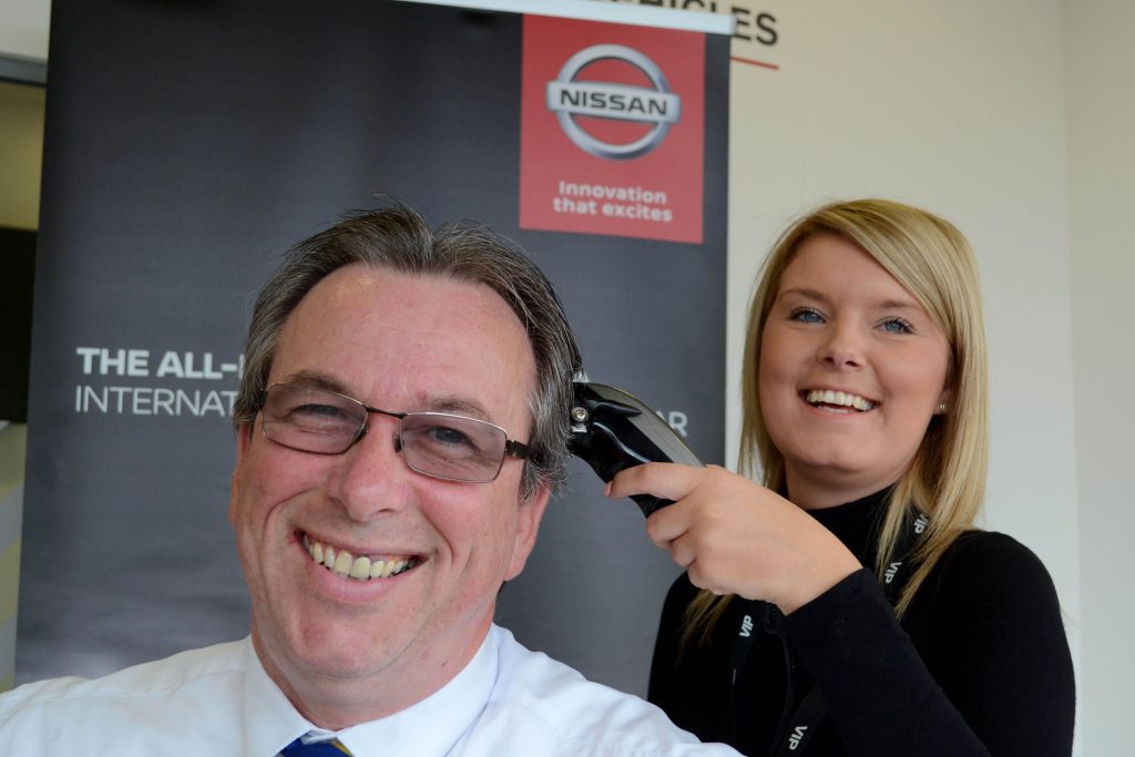 Ian Mcauliffe, New Car Sales Executive at Wessex Garages, gets his hair shaved by Jess Molloy, Service Advisor at Wessex Garages. 